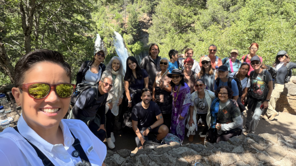 Rayani taking a selfie with a large group of retreat participants in nature