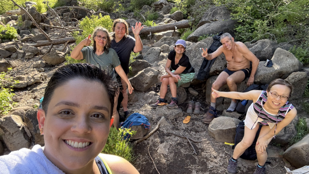 Rayani taking a selfie with retreat group resting near a forest stream